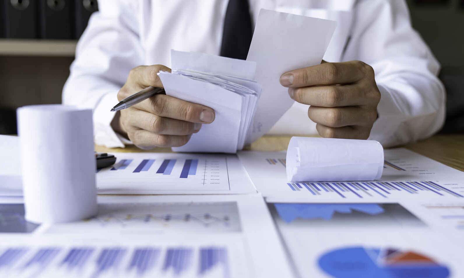 Close-up of businessman's hands collecting bills for tax refund and tax savings, finance banking and savings ideas