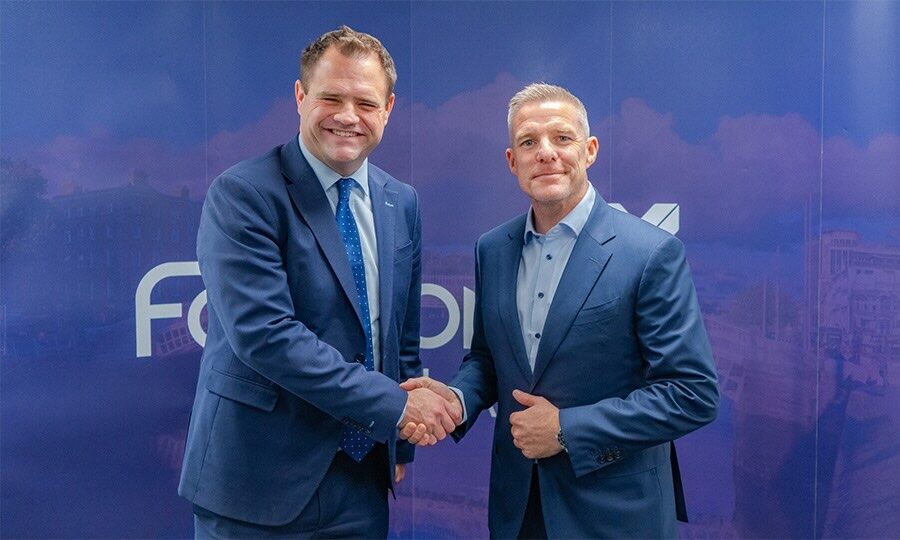Minister of Financial Services Neale Richmond and Fairstone Ireland CEO Paul Merriman shaking hands in front of Fairstone Ireland pull up banner