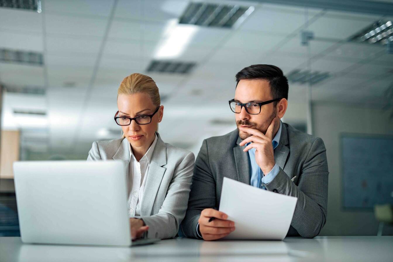 Portrait of a serious company management working with laptop - Corporate Investment Account
