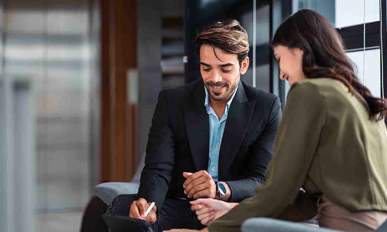 A man and woman discussing ideas together in a professional office environment.